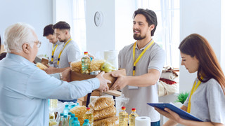 Menschen einer gemeinnützigen Organisationen verteilen Essen